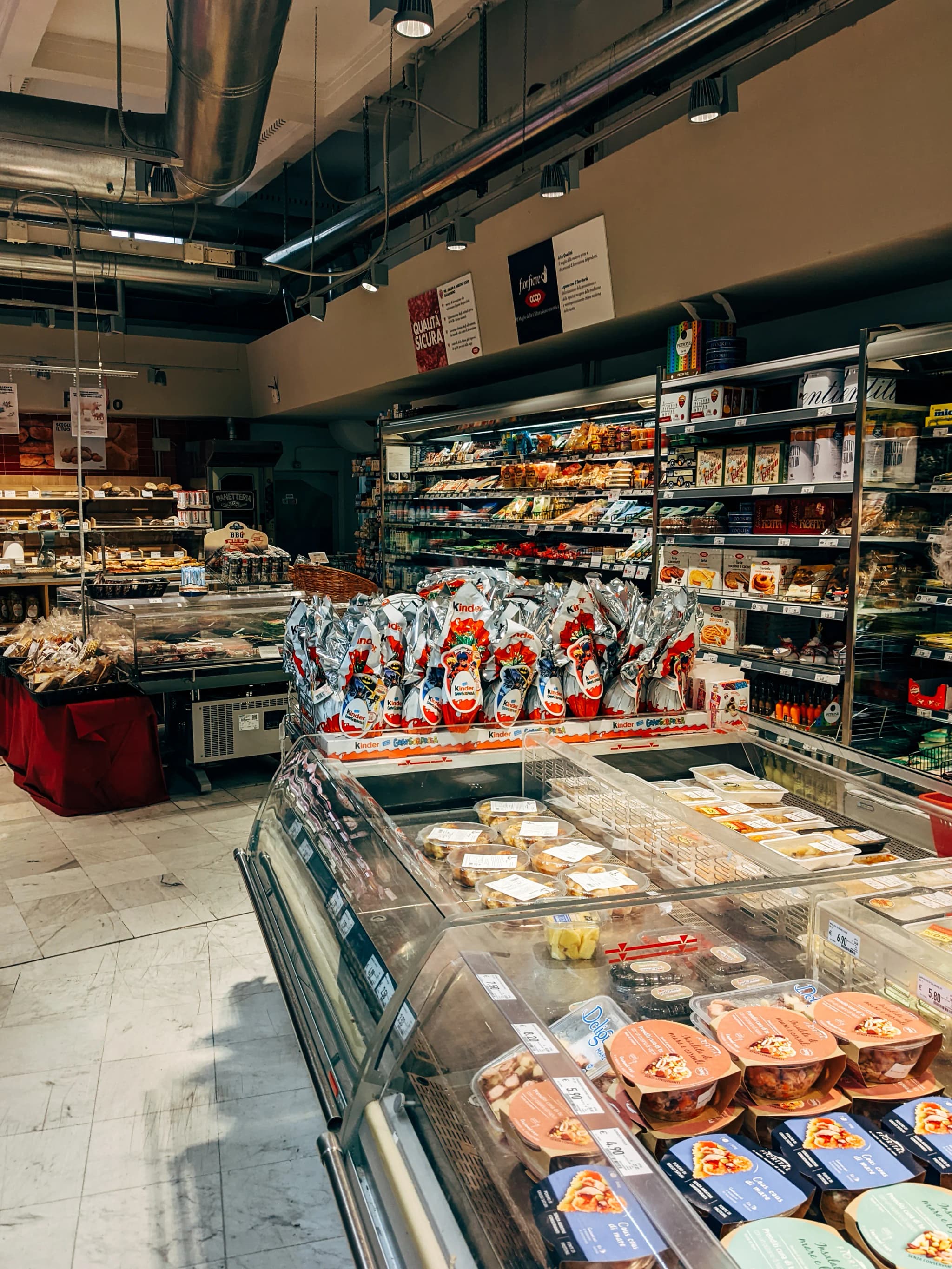 Gang in einem Supermarkt mit gefüllten Regalen und Lebensmitteln