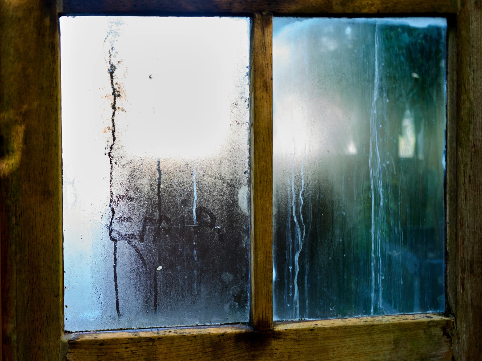 Beschlagene Fensterscheibe mit Kondenswasser im Holzrahmen: Schimmel am Fenster vorbeugen mit Glanz & Glimmer