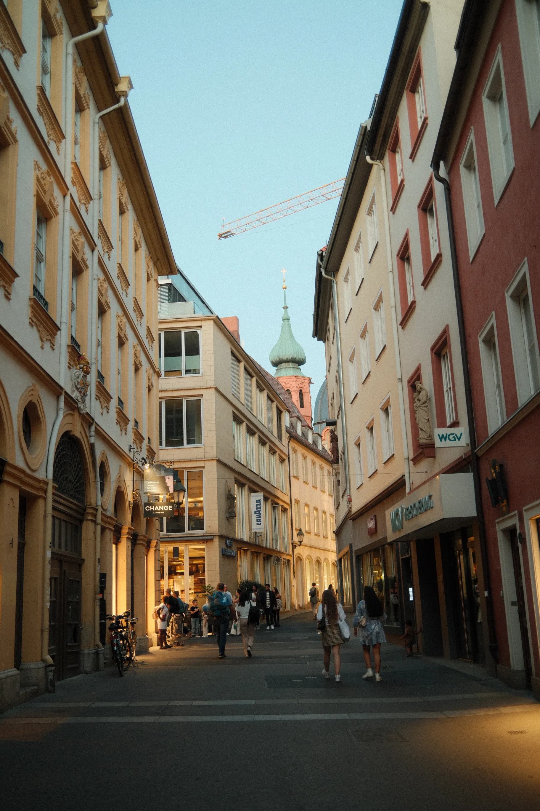 Historische Altstadtgasse mit bayerischen Fassaden und Passanten in einer Innenstadt