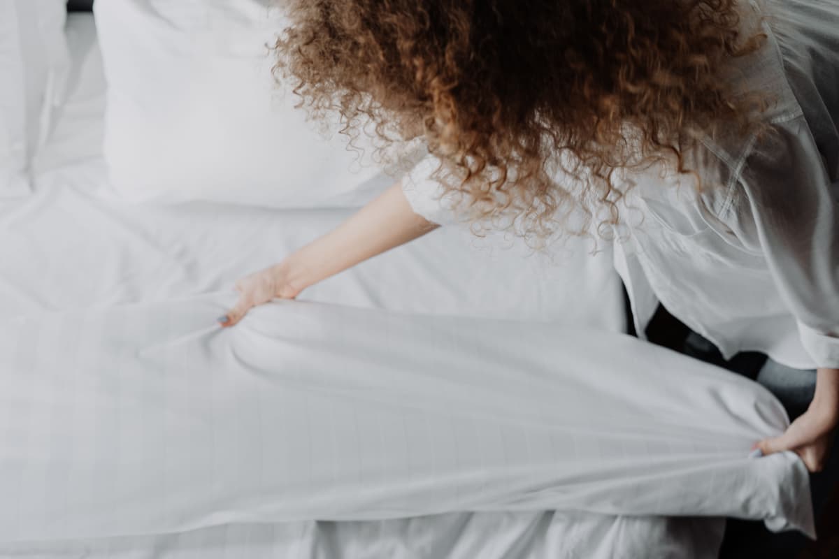 Frisch bezogenes Bett mit heller Bettwäsche: Milbenreduktion im Schlafzimmer mit Glanz & Glimmer