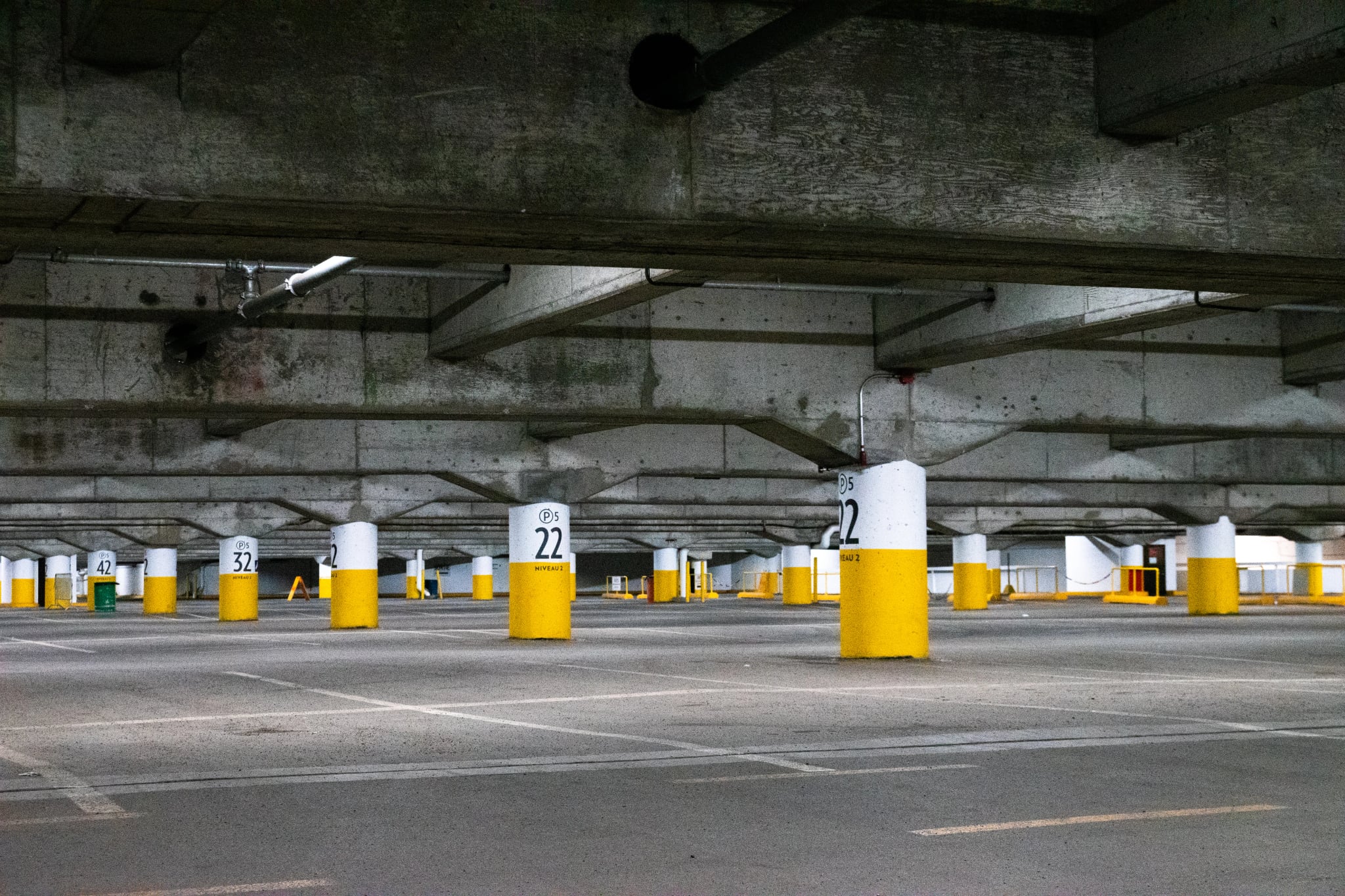 Leere Tiefgarage mit Betonstützen und Deckenbeleuchtung