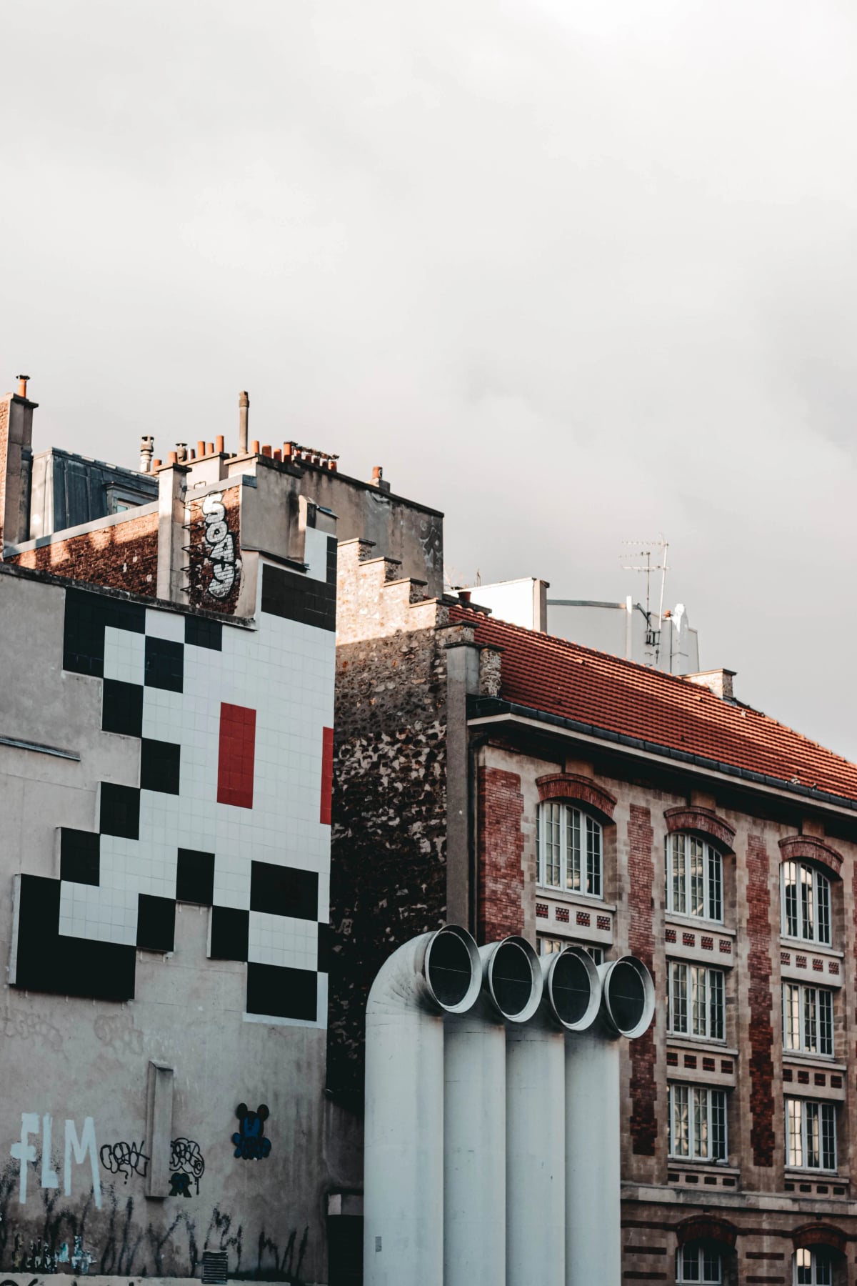 Fassade eines älteren Gebäudes mit großflächigem Graffiti auf dem Putz