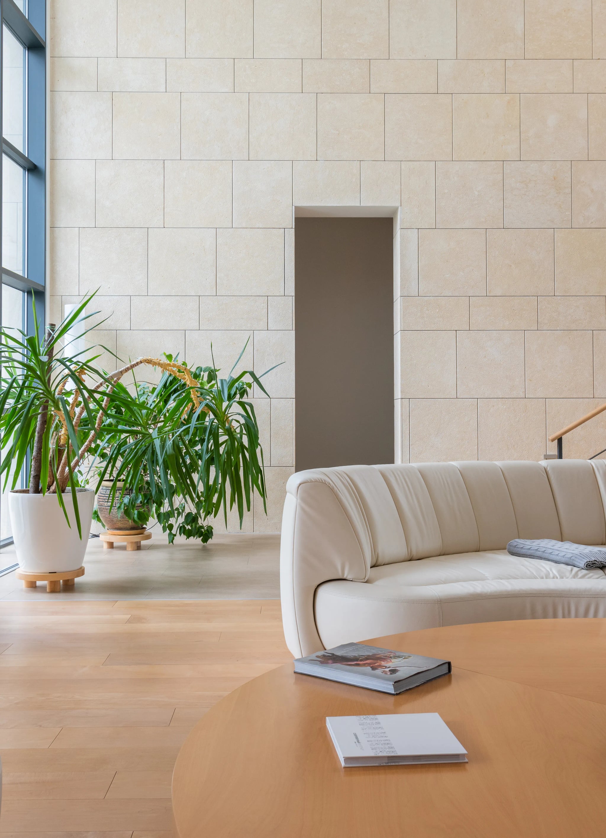 Helles Wohnzimmer mit einem gepolsterten Sofa und einem runden Holztisch