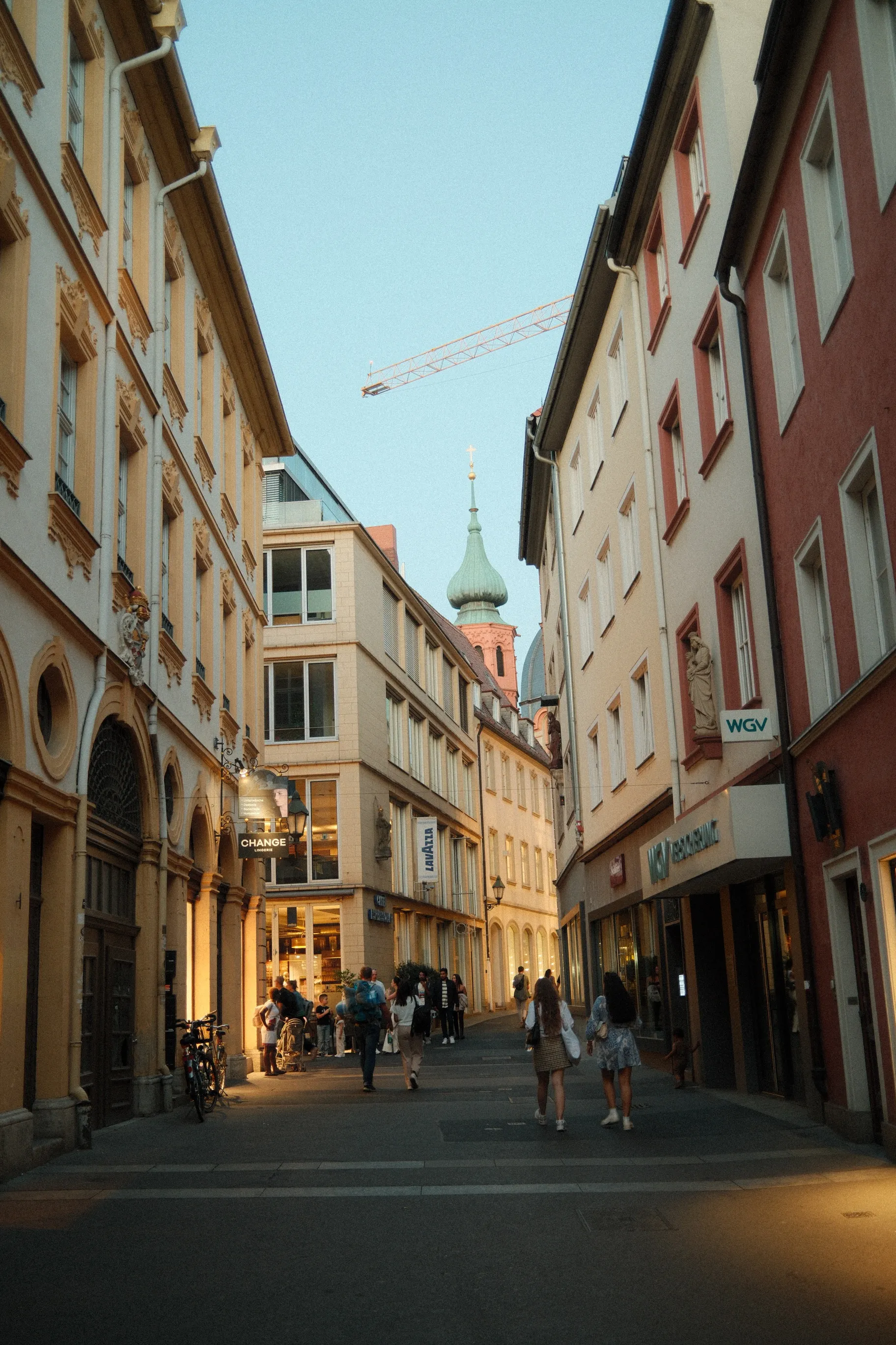 Historische Altstadtgasse mit bayerischen Fassaden und Passanten in einer Innenstadt