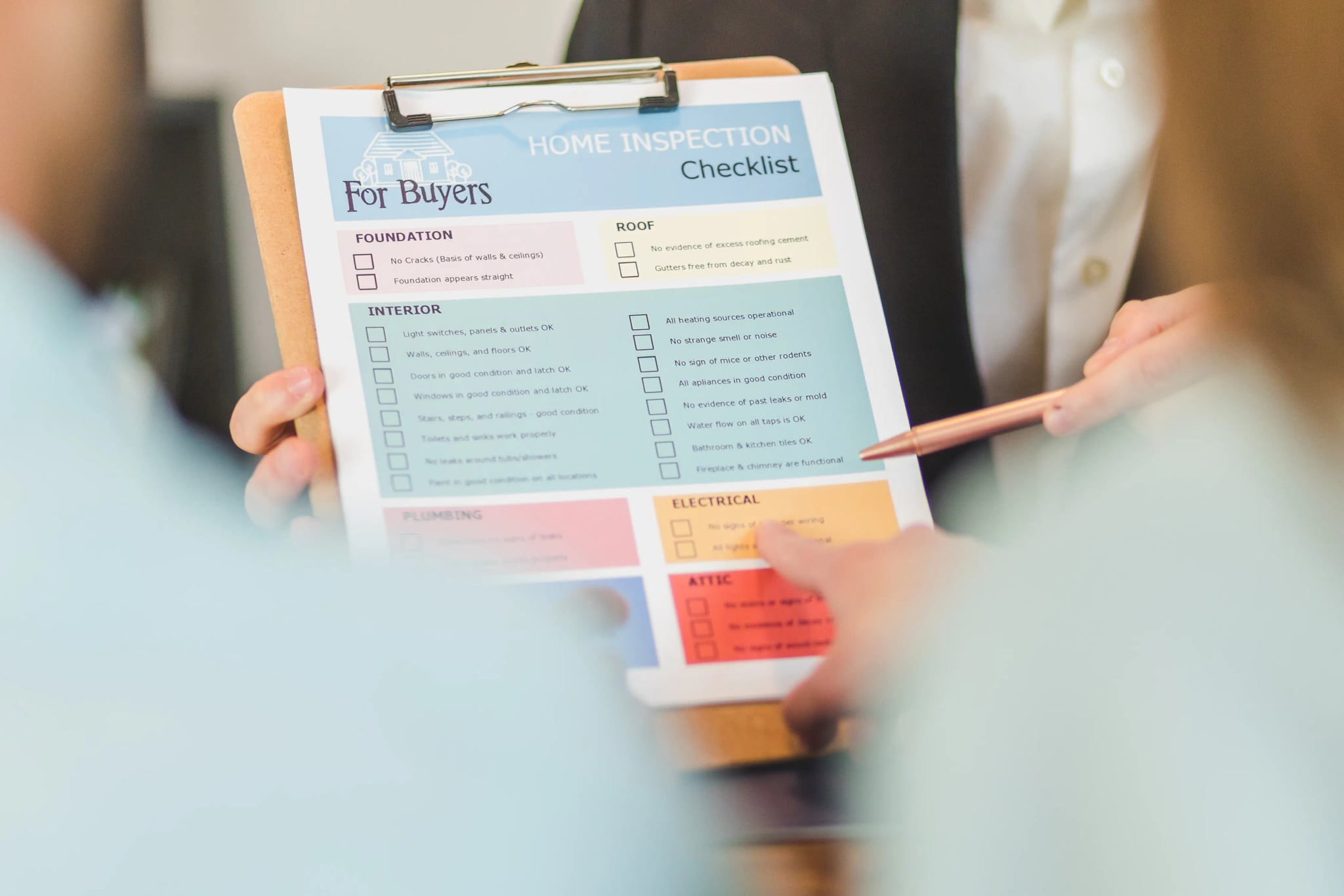Zwei Personen gehen gemeinsam eine gedruckte Checkliste auf einem Klemmbrett durch und zeigen mit einem Stift auf einen Punkt