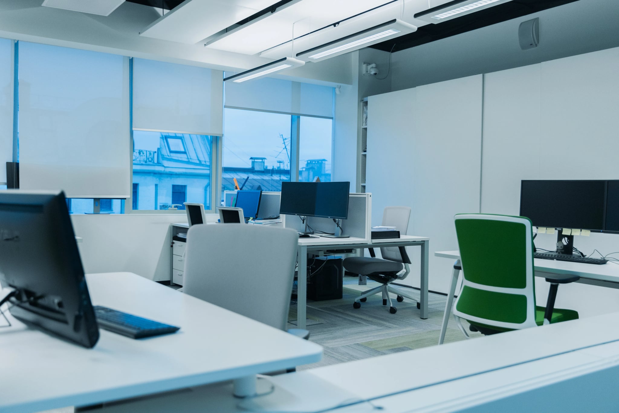 Helles Büro mit Computerarbeitsplätzen, Bürostühlen und großen Fenstern